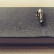 Ball pen on top of elegant notebook